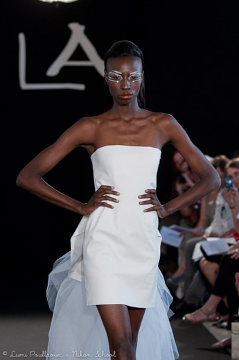 Robe de mariée blanche photographiée sur podium de défilé de mode à Paris
